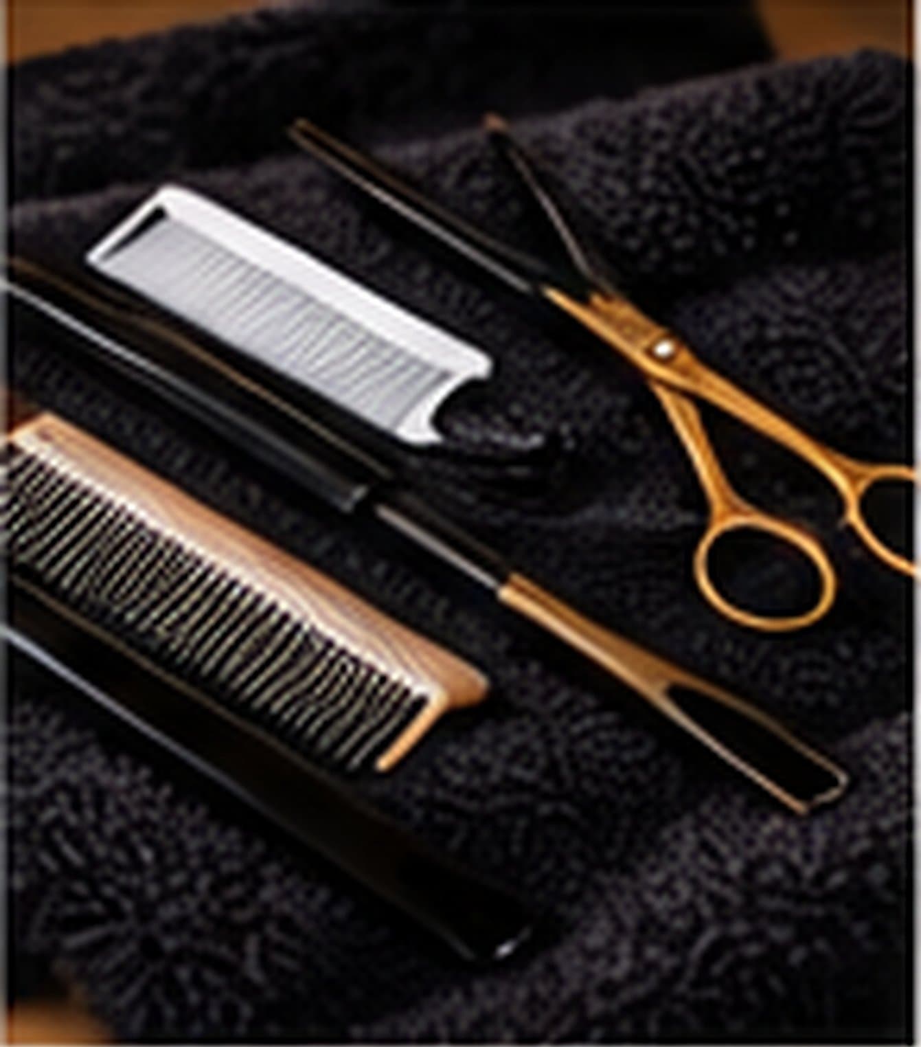 Hair oil in a wooden bowl, a wide-tooth comb and a finished braid